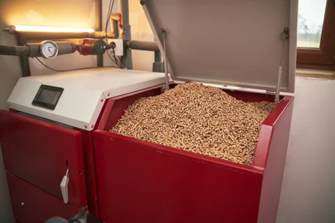 Intérieur d'une chaufferie domestique avec chaudière à granulés de bois rouge en fonctionnement