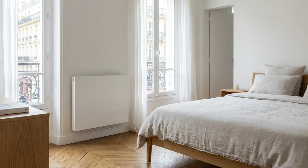 Intérieur d'une chambre moderne avec radiateur mural blanc moderne en aluminium, servant d'élément de chauffage, photographié sans personne, montrant l'intégration discrète du système de chauffage dans l'environnement résidentiel.
