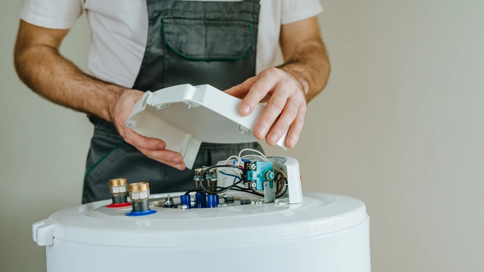 Photographie d'un chauffe-eau thermodynamique moderne installé dans un local technique résidentiel ou en salle de bain, montrant clairement le réservoir et l'unité de récupération de calories, idéalement en situation d'installation ou dans un environnement de maison contemporaine bien éclairé, sans personne visible